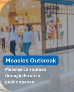 A blurred image of people walking in a shopping mall. A bold blue banner reads 'Measles Outbreak'. Below it, white text says 'Measles can spread through the air in public spaces.'