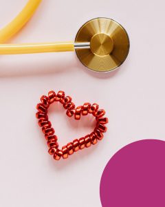 Yellow stethoscope on a light background beside a red heart shape made of coiled beads, symbolizing heart health and medical care.